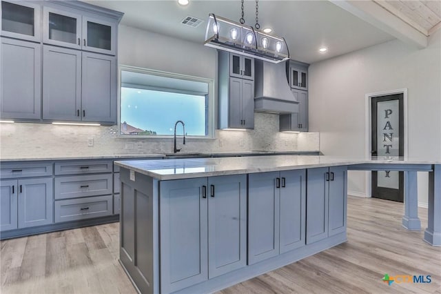 916 Stone Rd, Temple, TX 76501 - kitchen with a sink, visible vents, a center island, custom range hood, and light wood-style floors