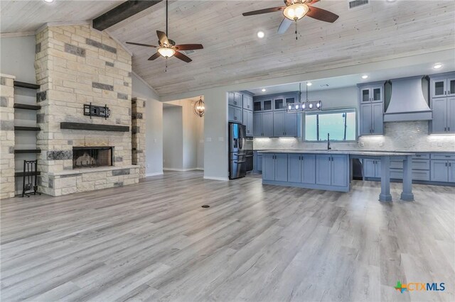 916 Stone Rd, Temple, TX 76501 - unfurnished living room with light wood-style flooring, wooden ceiling, ceiling fan, a sink, and a fireplace
