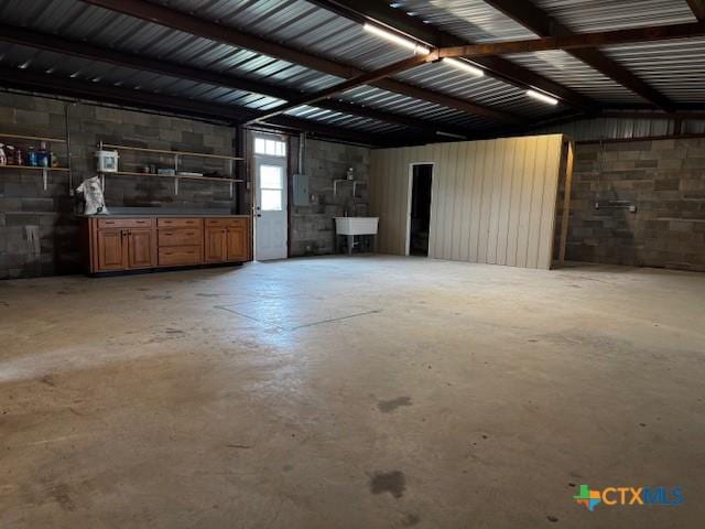 916 Stone Rd, Temple, TX 76501 - garage with electric panel, concrete block wall, and a sink