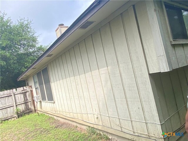 1318 Deupree Dr, Austin, TX 78753 - view of side of property featuring fence, a chimney, and board and batten siding