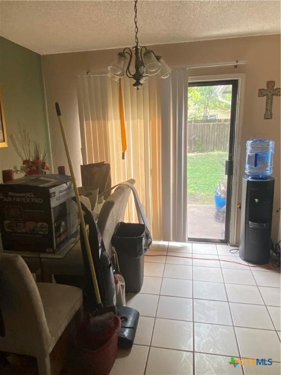1318 Deupree Dr, Austin, TX 78753 - dining area with a chandelier, a textured ceiling, and light tile patterned flooring