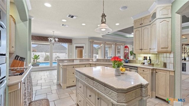 kitchen with decorative light fixtures, kitchen peninsula, and a kitchen island