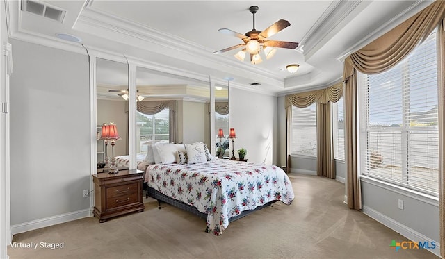 carpeted bedroom featuring ceiling fan, ornamental molding, and a tray ceiling