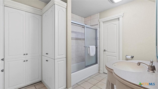 bathroom with combined bath / shower with glass door and tile patterned flooring