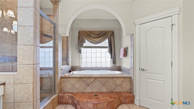 bathroom with tile patterned floors and shower with separate bathtub