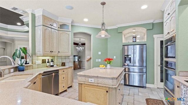 kitchen with appliances with stainless steel finishes, a kitchen island, backsplash, ornamental molding, and sink