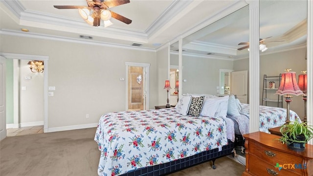 carpeted bedroom featuring ceiling fan, ornamental molding, and a tray ceiling