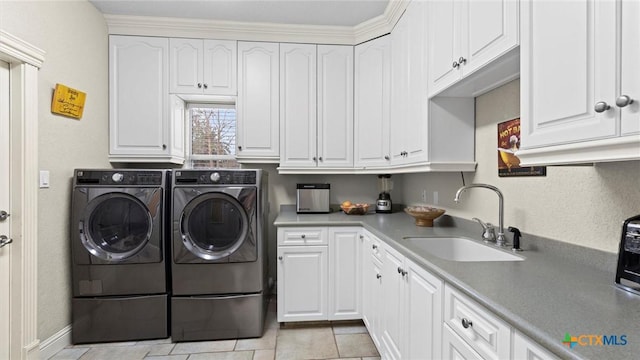 laundry area featuring cabinets, sink, light tile patterned floors, and separate washer and dryer