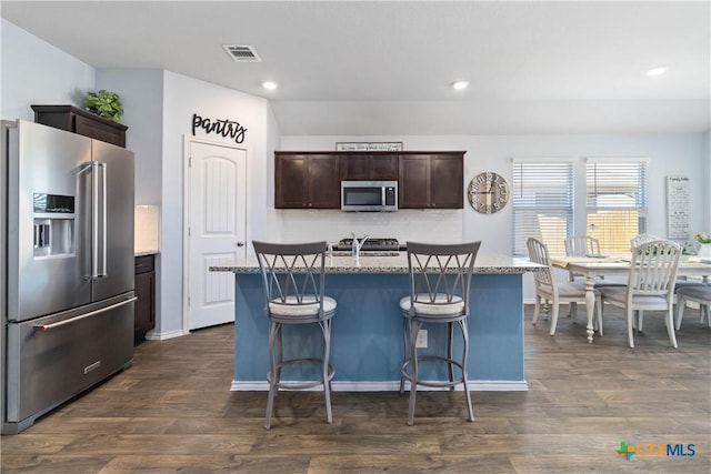 kitchen with visible vents, dark wood-type flooring, dark brown cabinetry, and appliances with stainless steel finishes