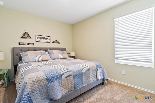 bedroom with multiple windows, baseboards, and carpet floors