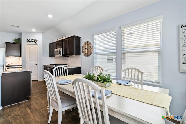 dining room featuring dark wood finished floors, lofted ceiling, recessed lighting, and visible vents