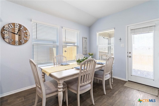 dining space featuring baseboards, lofted ceiling, and wood finished floors