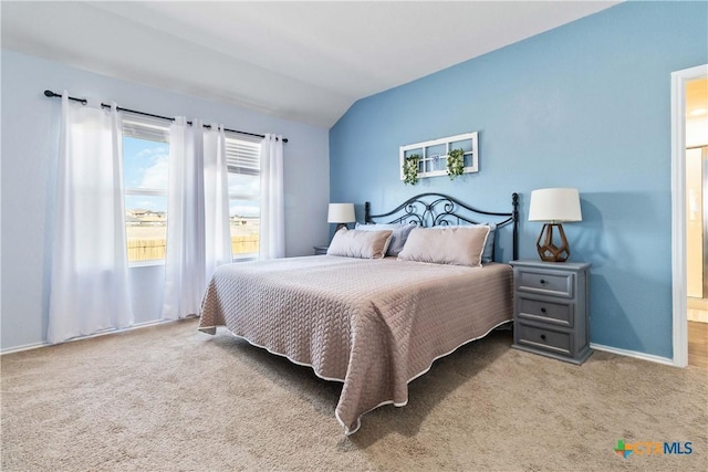 carpeted bedroom with baseboards and vaulted ceiling