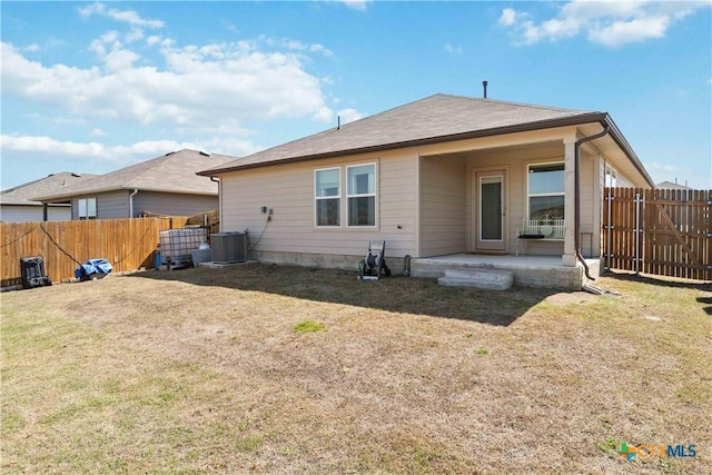 back of property with a patio area, central AC unit, a lawn, and fence private yard