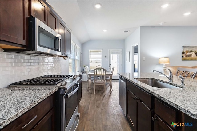 kitchen featuring dark wood-type flooring, a sink, light stone counters, appliances with stainless steel finishes, and dark brown cabinets