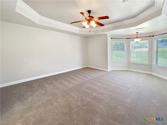 carpeted empty room featuring ceiling fan, a raised ceiling, and crown molding