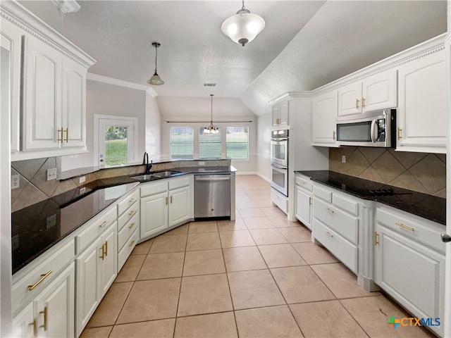 kitchen with sink, white cabinets, hanging light fixtures, and appliances with stainless steel finishes