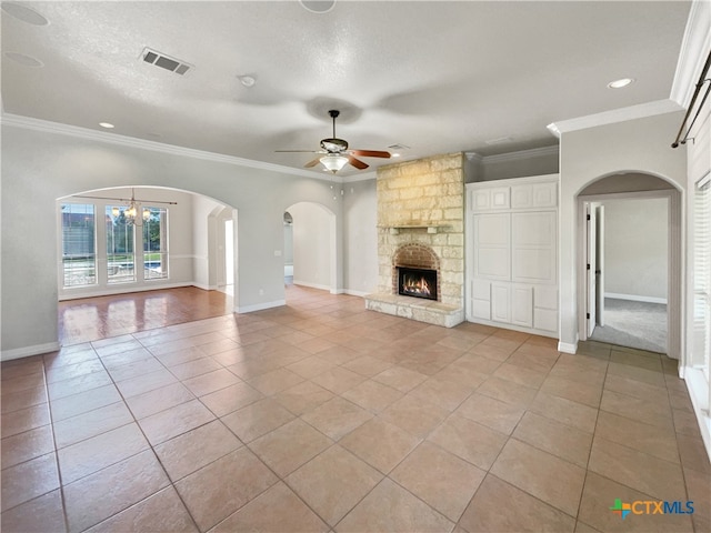 unfurnished living room with light tile patterned floors, ceiling fan with notable chandelier, a stone fireplace, and ornamental molding