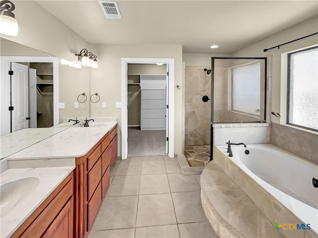 bathroom featuring tile patterned flooring, vanity, and shower with separate bathtub