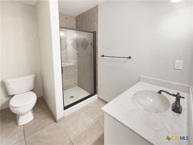 bathroom with tile patterned flooring, vanity, toilet, and a shower with shower door