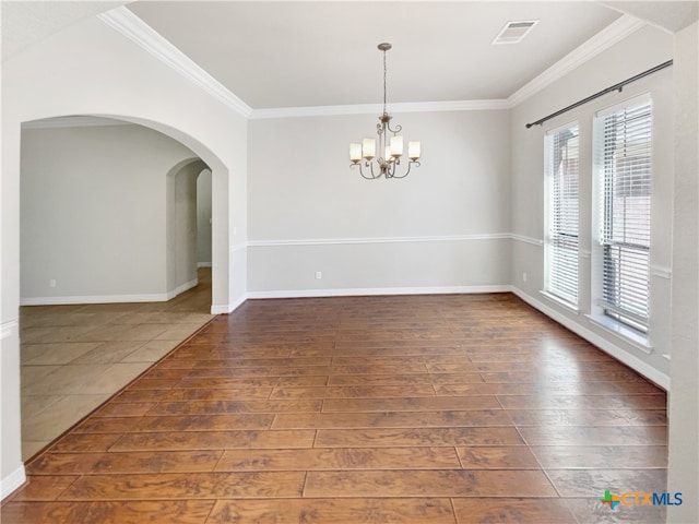 empty room with a chandelier, crown molding, and dark wood-type flooring