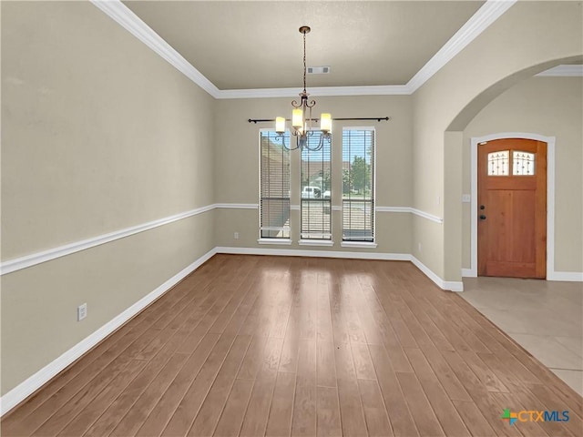 unfurnished dining area featuring hardwood / wood-style floors, a notable chandelier, and ornamental molding