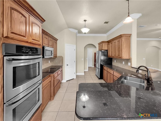 kitchen featuring backsplash, sink, pendant lighting, and appliances with stainless steel finishes