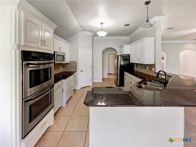 kitchen with backsplash, sink, white cabinets, and stainless steel appliances