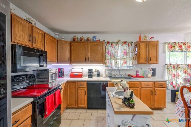 3302 Southhill Dr, Killeen, TX 76549 - kitchen with black appliances, a sink, light countertops, and light tile patterned floors