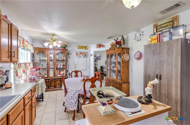 3302 Southhill Dr, Killeen, TX 76549 - kitchen featuring light tile patterned floors, ceiling fan, light countertops, and brown cabinetry