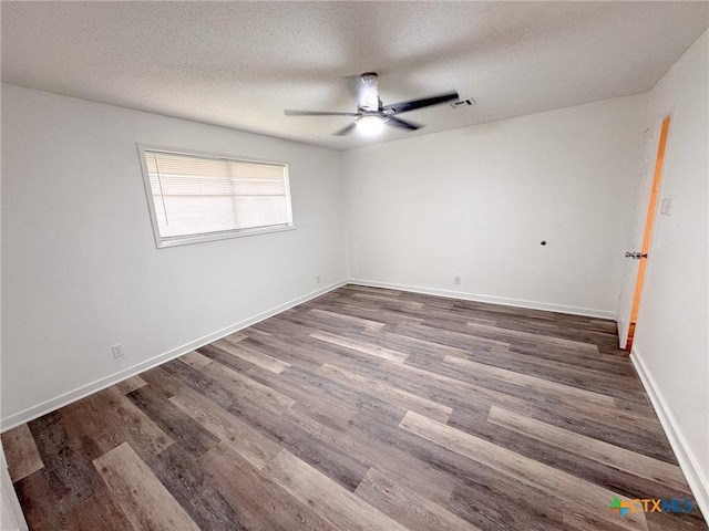 spare room with a textured ceiling, ceiling fan, and dark hardwood / wood-style flooring