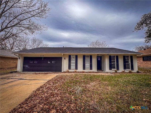 ranch-style house featuring a front lawn and a garage