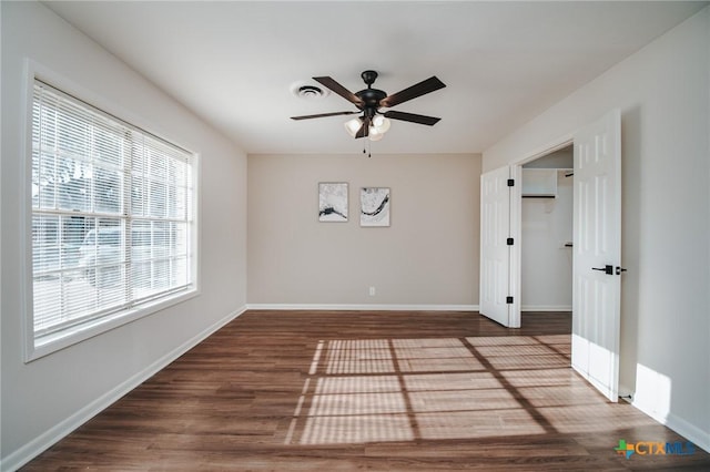 unfurnished room with ceiling fan and dark hardwood / wood-style flooring