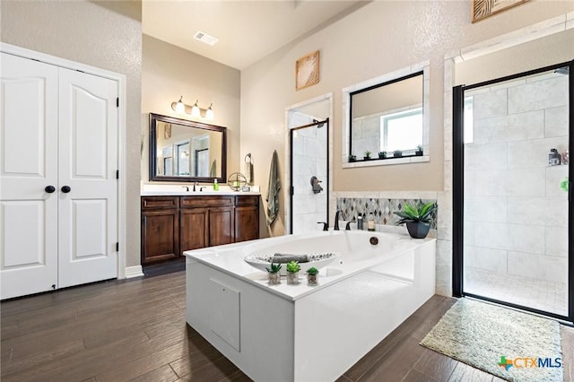 bathroom featuring vanity, wood-type flooring, and separate shower and tub