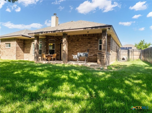 back of house featuring a patio area and a lawn