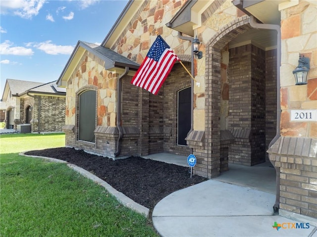 property entrance with a lawn