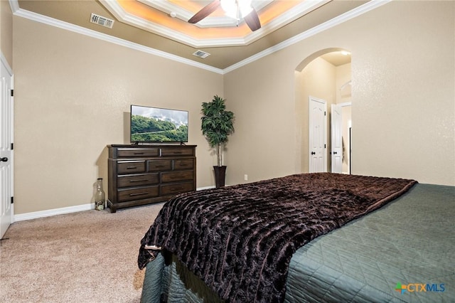 carpeted bedroom featuring ornamental molding, a raised ceiling, and ceiling fan