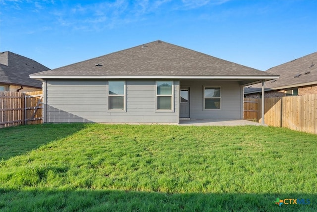 back of house featuring a lawn and a patio area