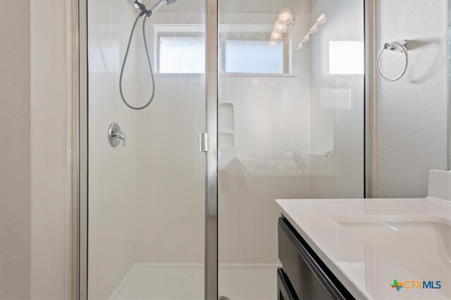 bathroom featuring walk in shower and vanity