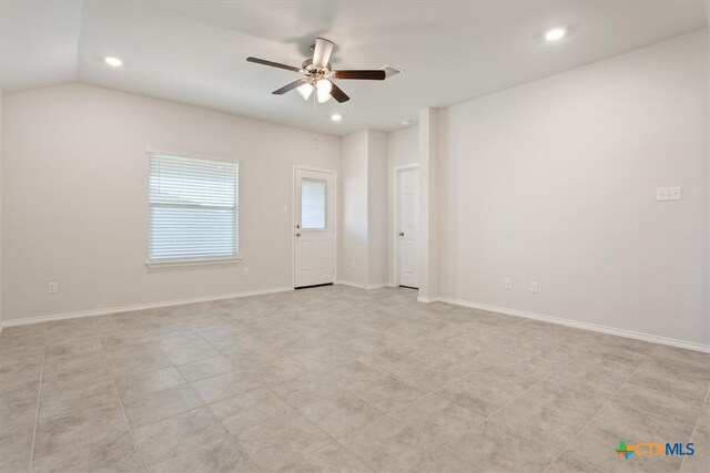 tiled spare room with ceiling fan and vaulted ceiling