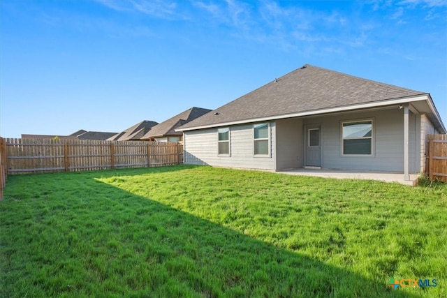 rear view of house with a yard and a patio area