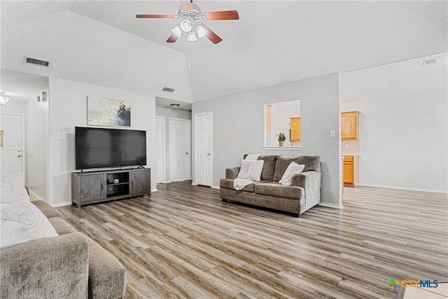 living room featuring ceiling fan, light hardwood / wood-style flooring, and high vaulted ceiling