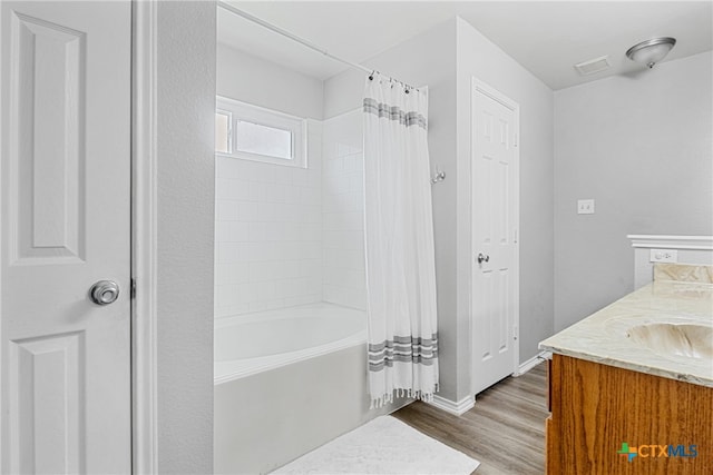 bathroom with wood-type flooring, vanity, and shower / bathtub combination with curtain