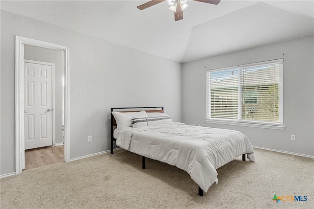 bedroom featuring ceiling fan, vaulted ceiling, and light colored carpet