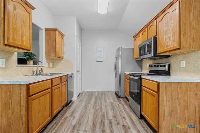 kitchen featuring stainless steel appliances, backsplash, sink, light hardwood / wood-style floors, and lofted ceiling