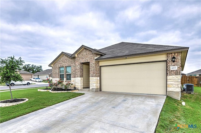 4001 Arafel Ln, Killeen, TX 76542 - view of front of home featuring a front lawn, driveway, stone siding, a garage, and brick siding