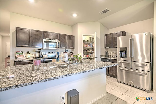 4001 Arafel Ln, Killeen, TX 76542 - kitchen with stone counters, visible vents, dark brown cabinetry, appliances with stainless steel finishes, and light tile patterned floors