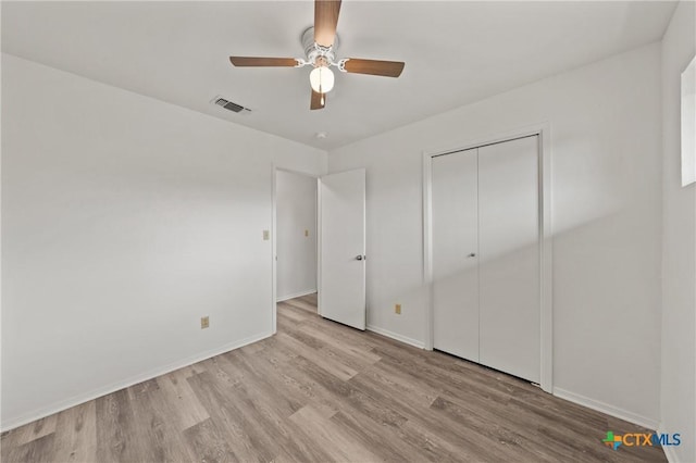 unfurnished bedroom featuring ceiling fan, a closet, and light wood-type flooring