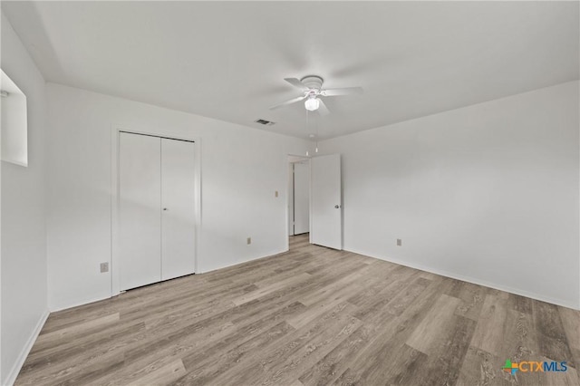 unfurnished bedroom with a closet, ceiling fan, and light hardwood / wood-style flooring