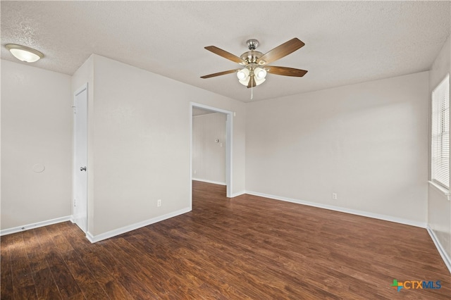 spare room featuring dark wood-type flooring, a textured ceiling, and ceiling fan